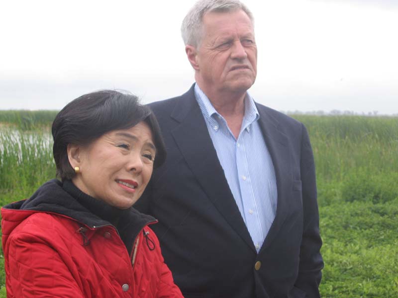 Congresswoman Doris Matsui and Congressman Collin Peterson listening and looking at someone off-camera while standing in the Conservancy's Fisherman's Lake Preserve Area