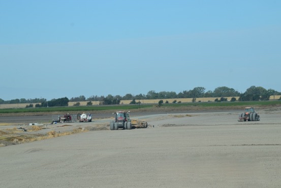 distant image of soil being mined by equipment for a levee project